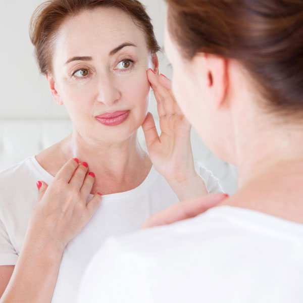 Woman looking at her facial skin