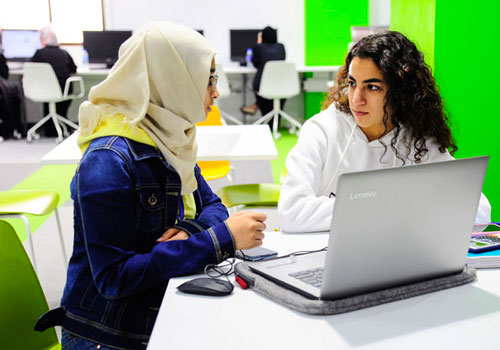 Female Information Technology students sitting behind laptops