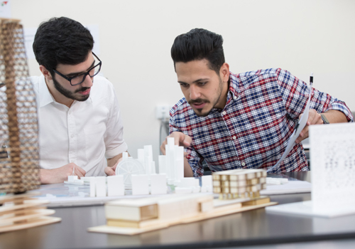 Two Bachelor of Architecture students using their skills to inspecting a 3D model