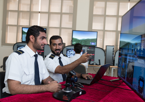 Two Aviation students looking at their flight simulation screen