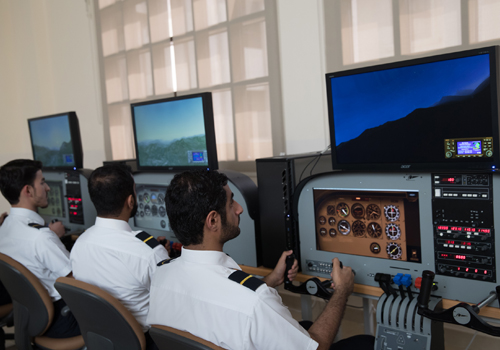 Three Bachelor of Aviation Management students using the flight simulators