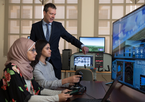 Bachelor of Aviation Management lecturer is assisting students during a flight simulator training