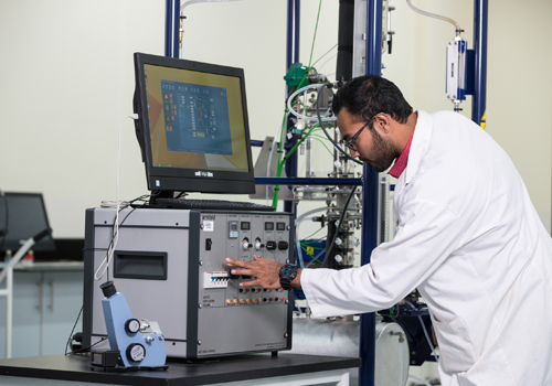 A Bachelor of Science in Chemical Engineering student operating some machinery at Abu Dhabi University