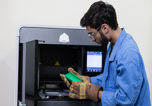 A Bachelor of Science in Civil Engineering student at Abu Dhabi University examining a green part