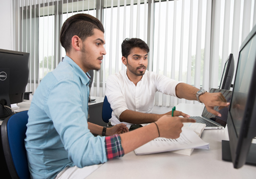 Two Bachelor's Degree in Computer Engineering Students going over course material on a computer