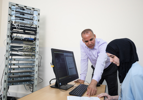 A Bachelor of Science in Cybersecurity Engineering lecturer guides a female student